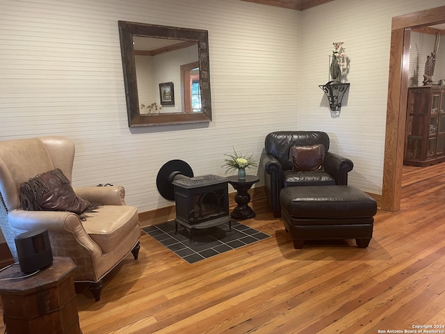 sitting room with a wood stove and hardwood / wood-style floors