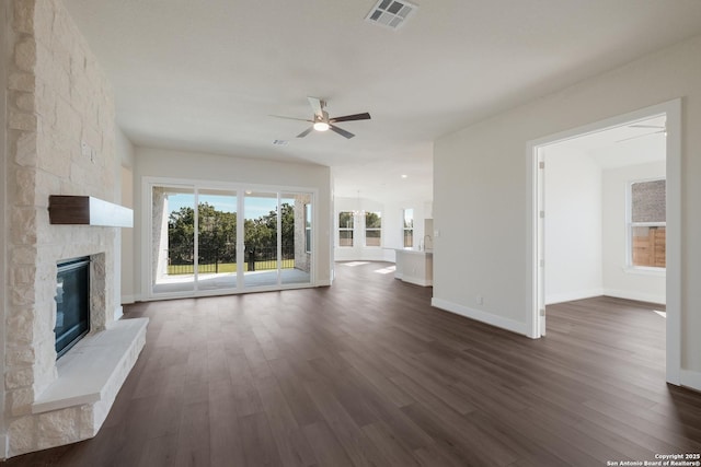 unfurnished living room featuring a fireplace, dark hardwood / wood-style floors, and ceiling fan