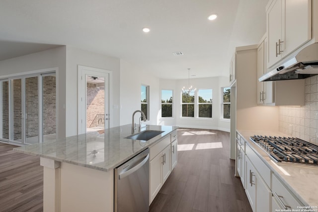 kitchen with sink, stainless steel appliances, dark hardwood / wood-style floors, decorative light fixtures, and a center island with sink