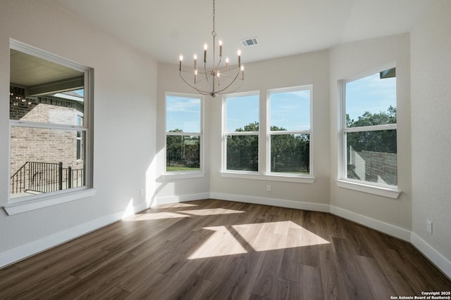 unfurnished dining area featuring a notable chandelier and dark wood-type flooring