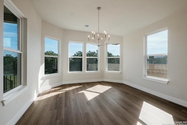 unfurnished dining area featuring dark hardwood / wood-style floors and an inviting chandelier