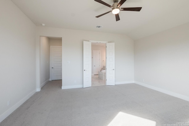 unfurnished bedroom with connected bathroom, ceiling fan, light colored carpet, and lofted ceiling