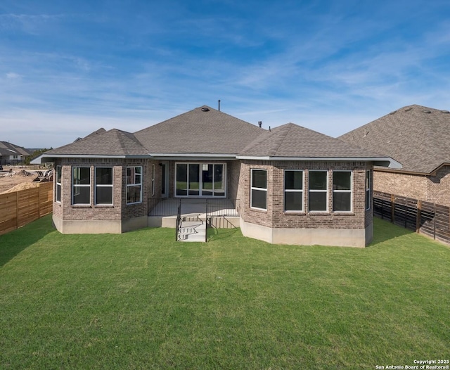 rear view of house featuring a yard