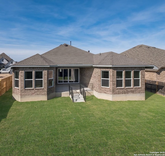 rear view of house featuring a lawn