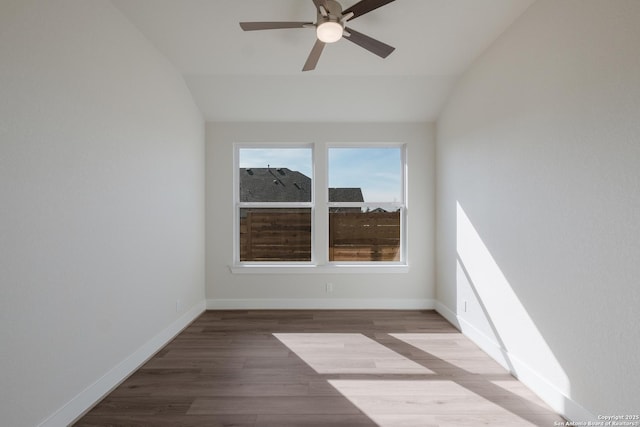 spare room with hardwood / wood-style floors, vaulted ceiling, and ceiling fan