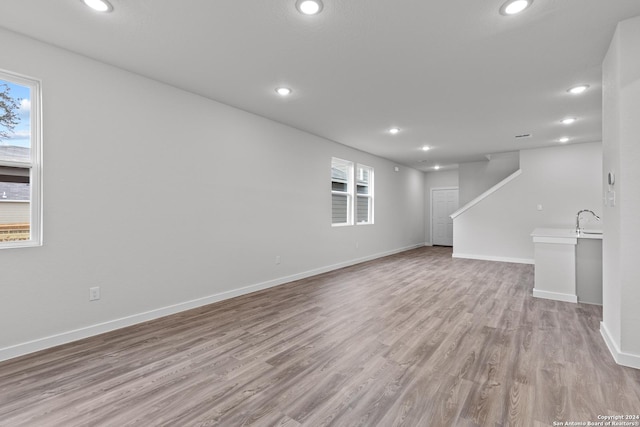 unfurnished living room featuring light hardwood / wood-style flooring and sink