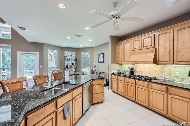 kitchen with ceiling fan, dark stone counters, sink, gas stovetop, and dishwasher