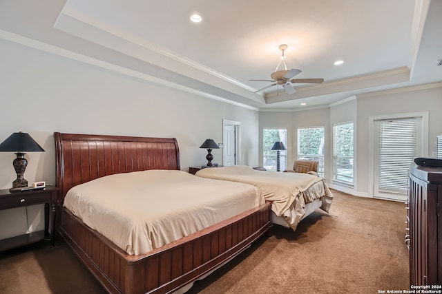 bedroom with crown molding, a tray ceiling, carpet, and ceiling fan