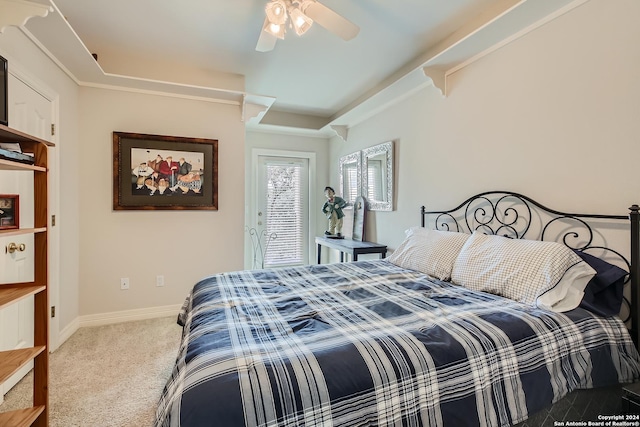bedroom with a tray ceiling, dark carpet, baseboards, and ornamental molding