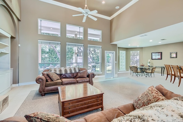 living room with a healthy amount of sunlight, ceiling fan, ornamental molding, and visible vents