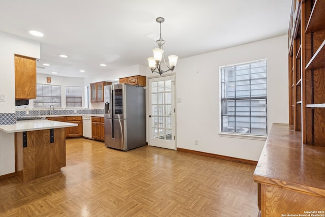 kitchen featuring a breakfast bar, kitchen peninsula, pendant lighting, a notable chandelier, and stainless steel fridge with ice dispenser