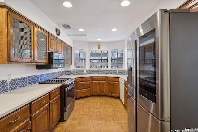 kitchen with stainless steel appliances, light parquet floors, and sink