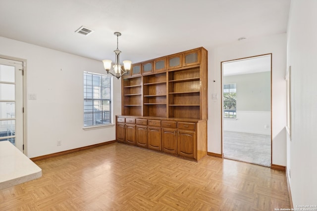 unfurnished dining area featuring a notable chandelier and light parquet floors