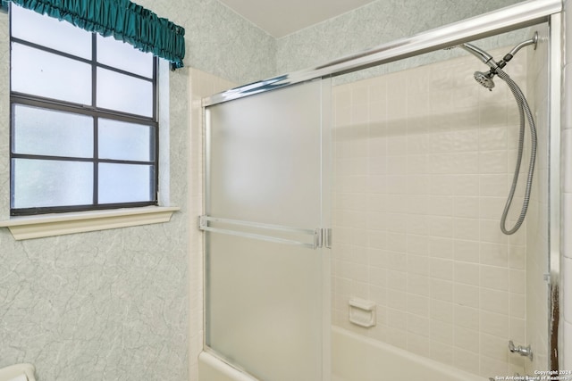 bathroom with bath / shower combo with glass door