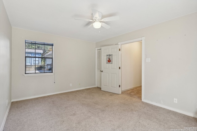 empty room with ceiling fan and light colored carpet