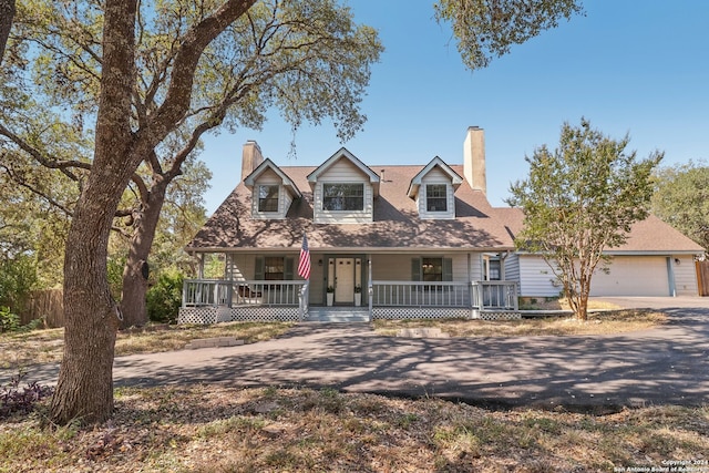 cape cod house with covered porch and a garage