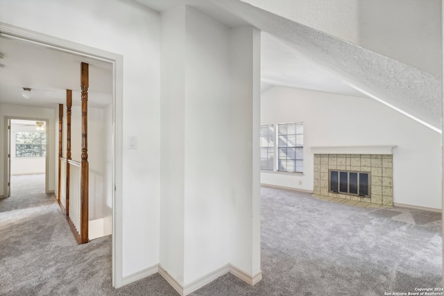 corridor featuring light colored carpet, vaulted ceiling, and a healthy amount of sunlight