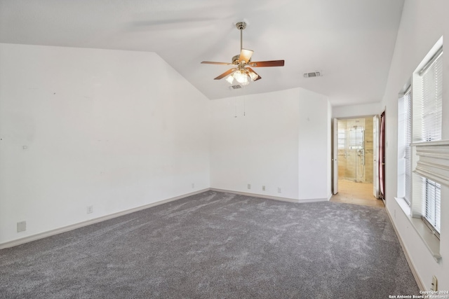 empty room featuring lofted ceiling, carpet flooring, and ceiling fan