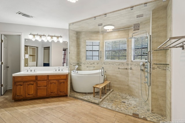 bathroom with independent shower and bath, vanity, and hardwood / wood-style flooring