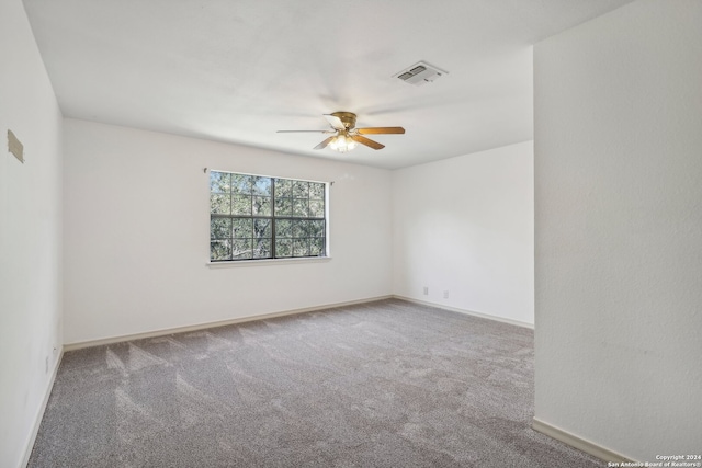 carpeted spare room featuring ceiling fan