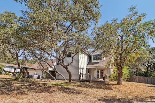 back of property with a yard and a wooden deck