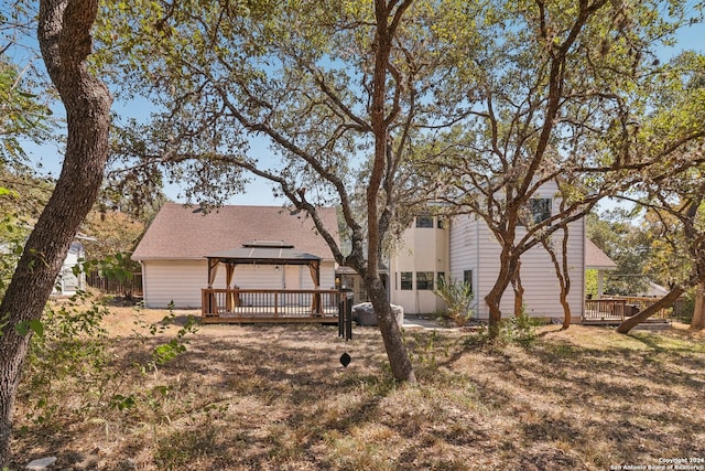 rear view of house featuring a gazebo and a wooden deck