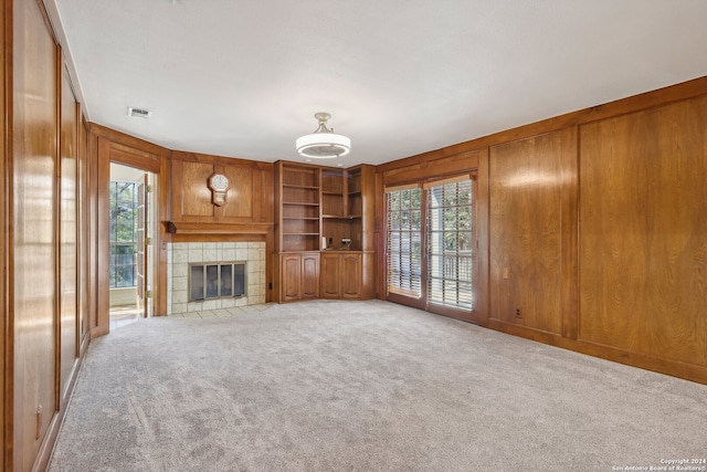 unfurnished living room with light carpet and wood walls