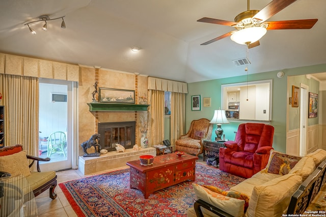 tiled living room featuring ceiling fan, a large fireplace, and lofted ceiling