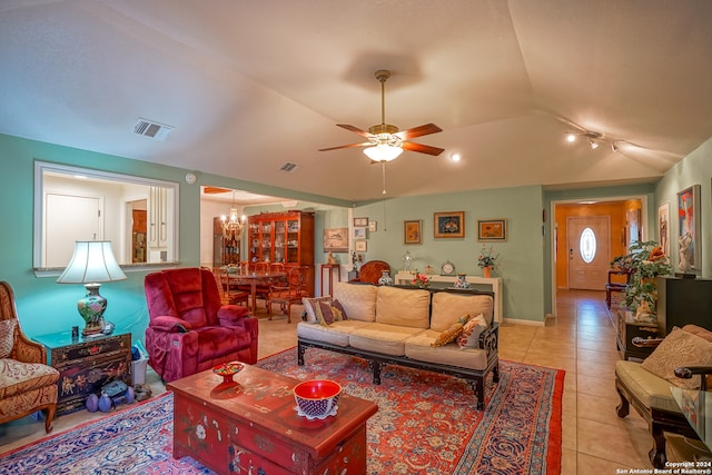 tiled living room featuring lofted ceiling and ceiling fan with notable chandelier