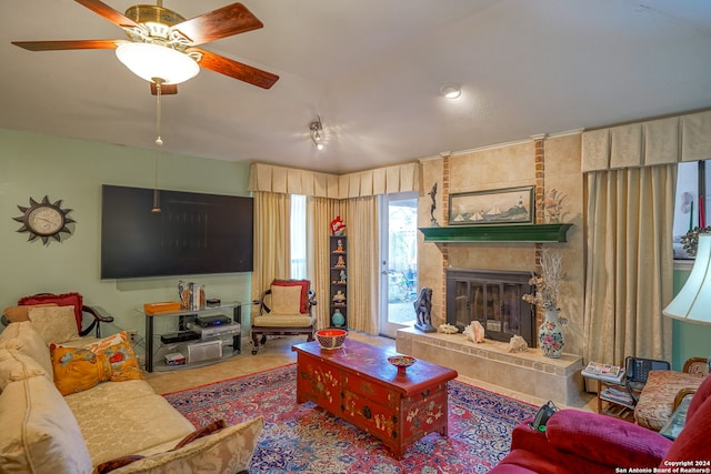 living room featuring tile patterned flooring, a large fireplace, and ceiling fan