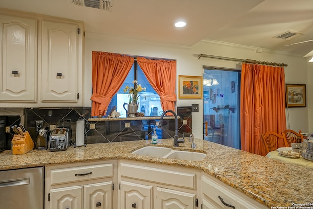 kitchen with tasteful backsplash, light stone countertops, sink, and ornamental molding