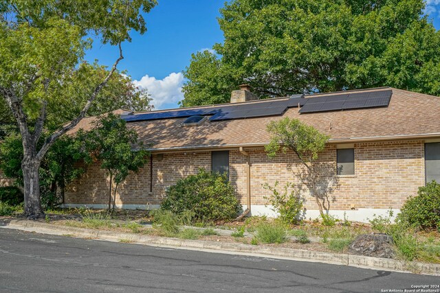 view of side of property featuring solar panels