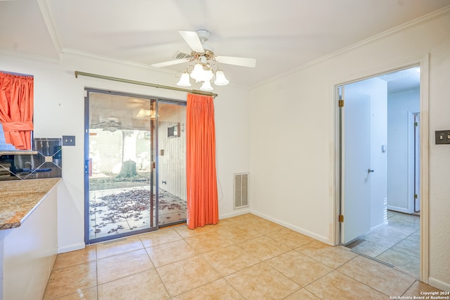 tiled dining area featuring crown molding and ceiling fan