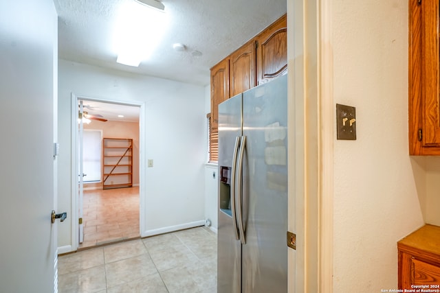 kitchen featuring stainless steel refrigerator with ice dispenser, a textured ceiling, light tile patterned floors, and ceiling fan