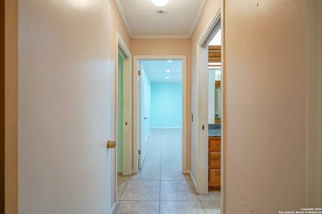 hallway with light tile patterned floors and ornamental molding