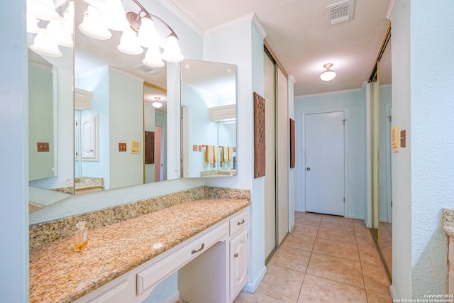 bathroom featuring tile patterned floors, vanity, ornamental molding, and a textured ceiling