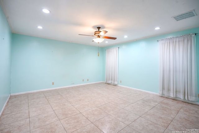 tiled empty room featuring ceiling fan