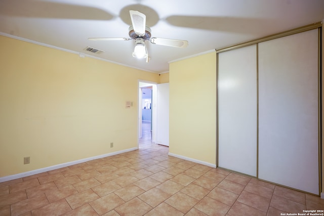 unfurnished bedroom featuring ceiling fan, crown molding, and a closet