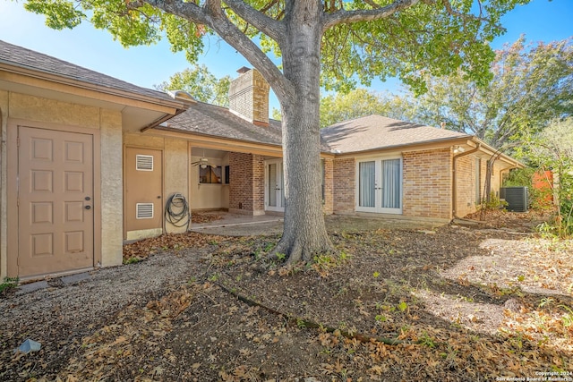 rear view of property with central air condition unit, french doors, and a patio