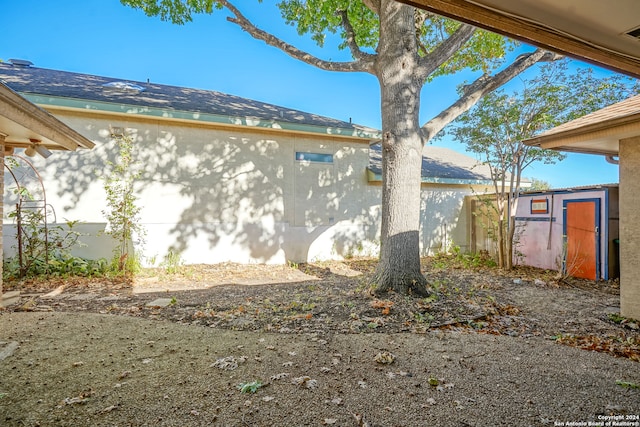 view of side of home with a storage shed