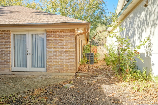 view of side of home featuring french doors and central air condition unit