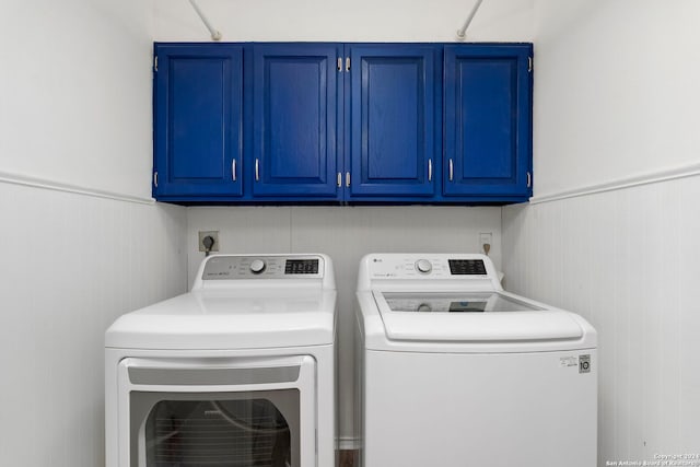 laundry area with washing machine and dryer and cabinets