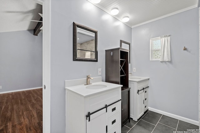 bathroom with ornamental molding, vaulted ceiling, tile patterned flooring, and vanity