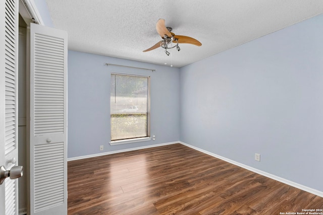 unfurnished bedroom with ceiling fan, a closet, dark hardwood / wood-style floors, and a textured ceiling