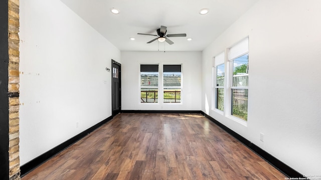 empty room with ceiling fan and dark hardwood / wood-style flooring