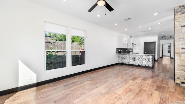 kitchen with ceiling fan, white cabinets, hardwood / wood-style floors, and kitchen peninsula