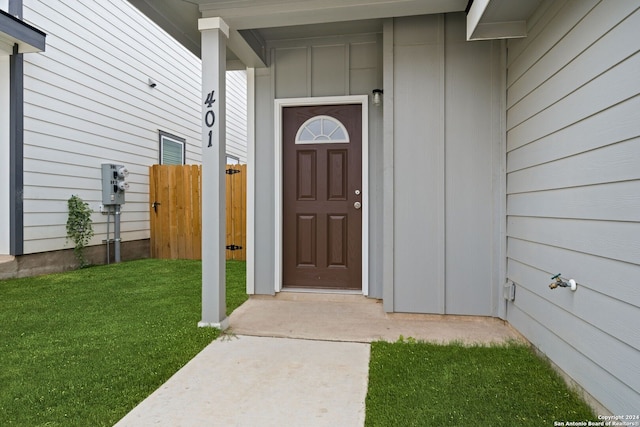 doorway to property with a lawn