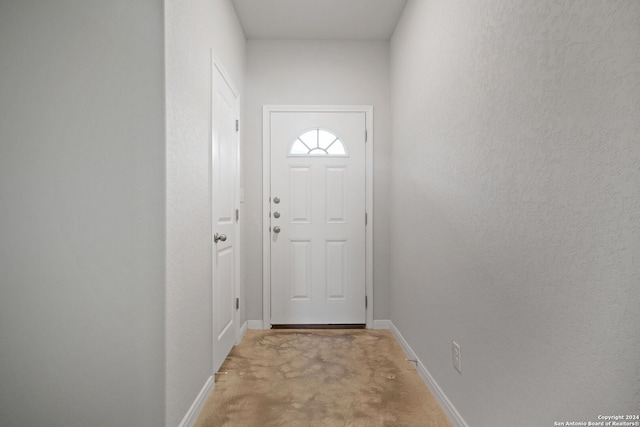 doorway to outside with light carpet