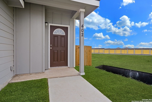 entrance to property with a lawn