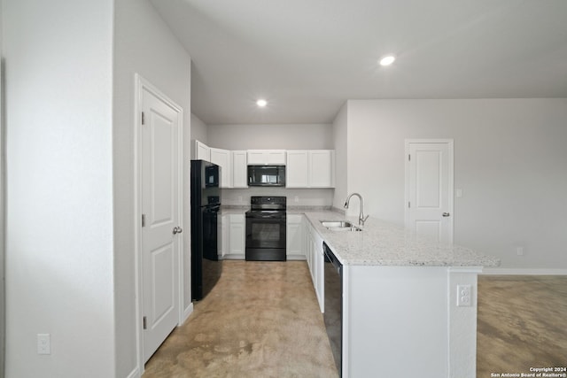 kitchen with white cabinets, light stone countertops, black appliances, sink, and light carpet